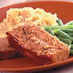 meatloaf, green beans and mashed potatoes on a red plate