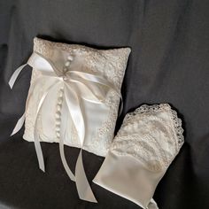 two white wedding garters on a black sheet with a satin bow and ribbon