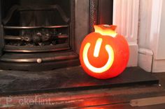 a carved pumpkin sitting in front of a fire place with the letter u on it