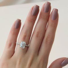 a woman's hand with a ring on it and a diamond in the middle