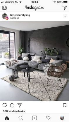 an instagram photo of a living room with grey couches and white rugs