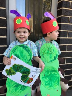 two young boys dressed up as the very hungry caterpillars and holding a book