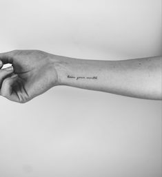 a person's arm with a small tattoo on the left side of their arm