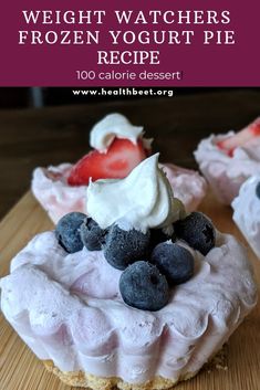 some desserts are sitting on a table with strawberries and blueberries in them