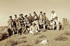 a group of people sitting on top of a dirt hill next to each other in the desert