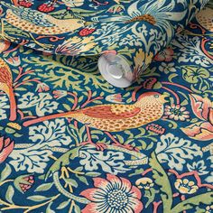 an image of a blue and red floral print fabric with birds on the background, close up