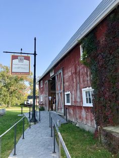 an old red barn with a sign on the side and stairs leading up to it