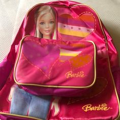 a barbie doll in a pink backpack with hearts on the front and back pocket,