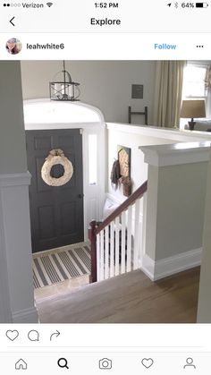 an entry way with a wreath on the front door and stairs leading to another room