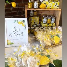 a table with lemons and candies on it next to a sign that says love is sweet