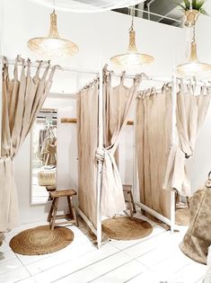 a room with curtains and stools in the corner, some hanging from ceiling lights