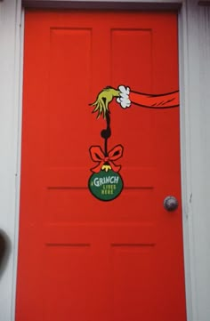 the grinch door is painted red and has a green hat on it's head