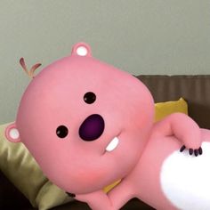 a pink bear laying on top of a brown couch