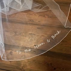 the bride's veil has writing on it that says to the moon and back