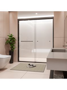 a bathroom with a sink, toilet and shower stall in the corner next to a potted plant