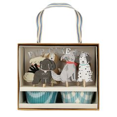 three cupcakes in a box with dogs on them