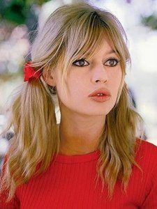 a woman with long blonde hair wearing a red shirt and holding a fork in her hand