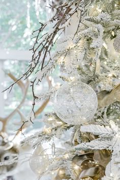 a white christmas tree with gold and silver ornaments