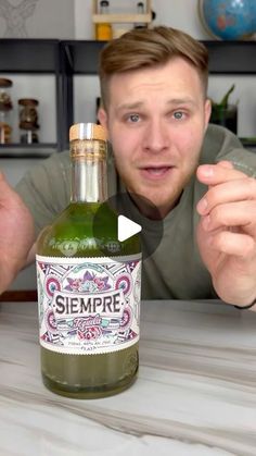 a man pointing at a bottle of wine on a table with the words sempre in front of him