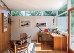 a home office with wood floors and windows on the wall, along with an area rug