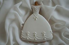 a cookie shaped like a wedding dress on white fabric