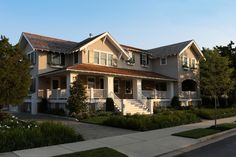 two story house with white balconies and brown shingles on the second floor