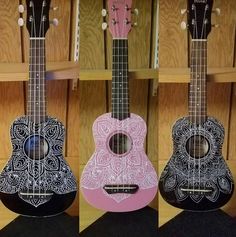 three guitars are shown with different designs on them, one is pink and the other is black