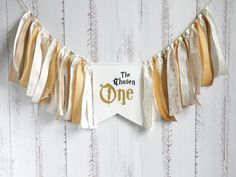 a banner that says the chosen one hanging from a string on a white wooden wall