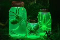 three jars filled with green liquid sitting on top of a table