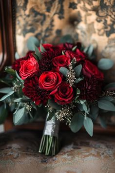 a bouquet of red flowers sitting on top of a chair