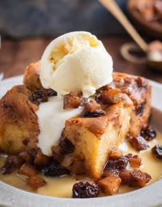 a piece of bread pudding topped with ice cream and raisins on a plate