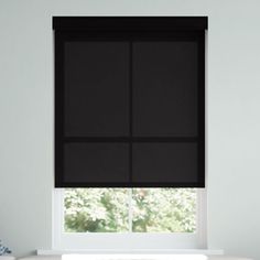 a window with black roller shades in a white room