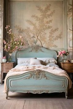 a bed sitting in a bedroom next to a dresser with flowers on top of it