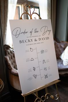 a sign that says order of the day on it in front of a chair and window