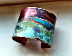 a colorful cuff bracelet sitting on top of a white table next to a window sill