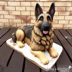 a german shepard dog figurine sitting on a wooden table with bricks in the background