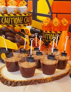 desserts and candies are arranged on a wood slice at a construction themed birthday party