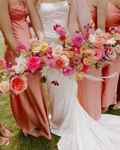 the bride and her bridesmaids are holding bouquets in their hands while standing on the grass