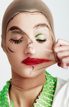 a woman with her face painted to look like marilyn monroe, wearing green and red beads