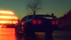 a car driving past an american flag at night