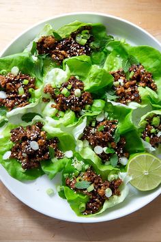 lettuce wraps with meat and garnishes on a white plate