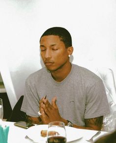 a man sitting at a table with his hands clasped