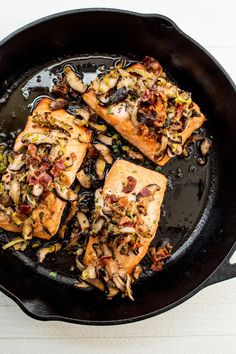 salmon with mushrooms in a skillet on a table