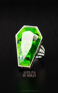 Avelina has made a strong entrance into the world of Gothic Jewelry with this meticulously designed Coffin Ring. Avelina's blood, sweat, and tears went into perfecting this design (which actually came to her in a recent dream! In which she saw the housing of the stone resembling the shape of a casket). Most of Avelinas favorite rings in her personal collection feature large AF faceted stones, and this ring was surely going to trump them all! Featuring a massive 3.3cm coffin-shaped stone, the fac Fantasy Rings For Halloween Gift, Gothic Gemstone Jewelry For Collectors, Gothic Collectible Gemstone Jewelry, Collectible Gothic Gemstone Jewelry, Gothic Green Jewelry For Gifts, Green Gothic Jewelry For Gifts, Green Gothic Jewelry Gift, Green Gothic Style Jewelry Gift, Coffin Ring