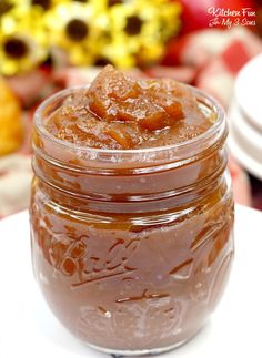 a jar filled with caramel sauce sitting on top of a white plate