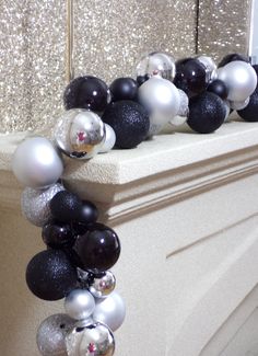 black and white ornaments are hanging on the mantle