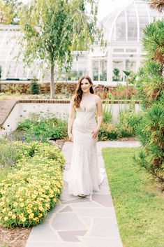 a woman in a white dress walking down a path