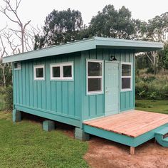 a small blue cabin with steps leading up to it