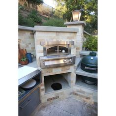 an outdoor kitchen with stone walls and grill