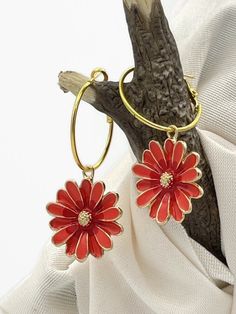 Large Orange Red Daisy Flower Earrings that will make a statement. Gold Plated, Enameled Charms that are 3 dimensional. The 1-inch diameter hoop is gold-plated brass and has a lever-back closure. These add a nice pop of color with blue jeans or a matching outfit.  The total earring length is 2 inches measuring from the top of the hoop to the bottom of the dangle drop. I ship quickly, package carefully, and am excited foryou to get your special items.   Handmade with Love in Minnesota Daisy Jewelry, Red Daisy, Dangle Hoop Earrings, Matching Outfit, Earrings Red, Orange Flower, Enamel Earrings, Enamel Charms, Earrings Statement